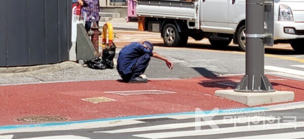 사진 설명 : 구례읍 장날 번잡한 사거리 건널목에서 주저앉아 있는 노인의 모습이다.